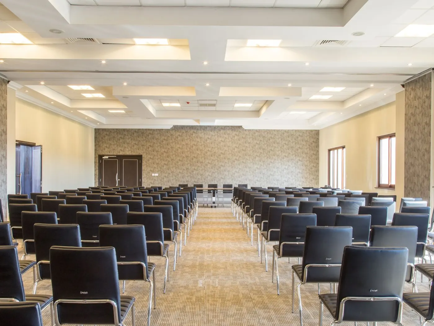 Sala preparada para una junta de propietarios, con las sillas alineadas frente a la mesa presidencial
