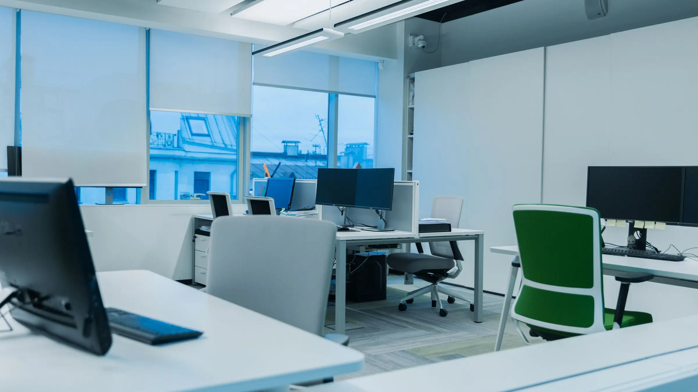 Oficina luminosa con puestos de trabajo y ventanas que dan a la calle
