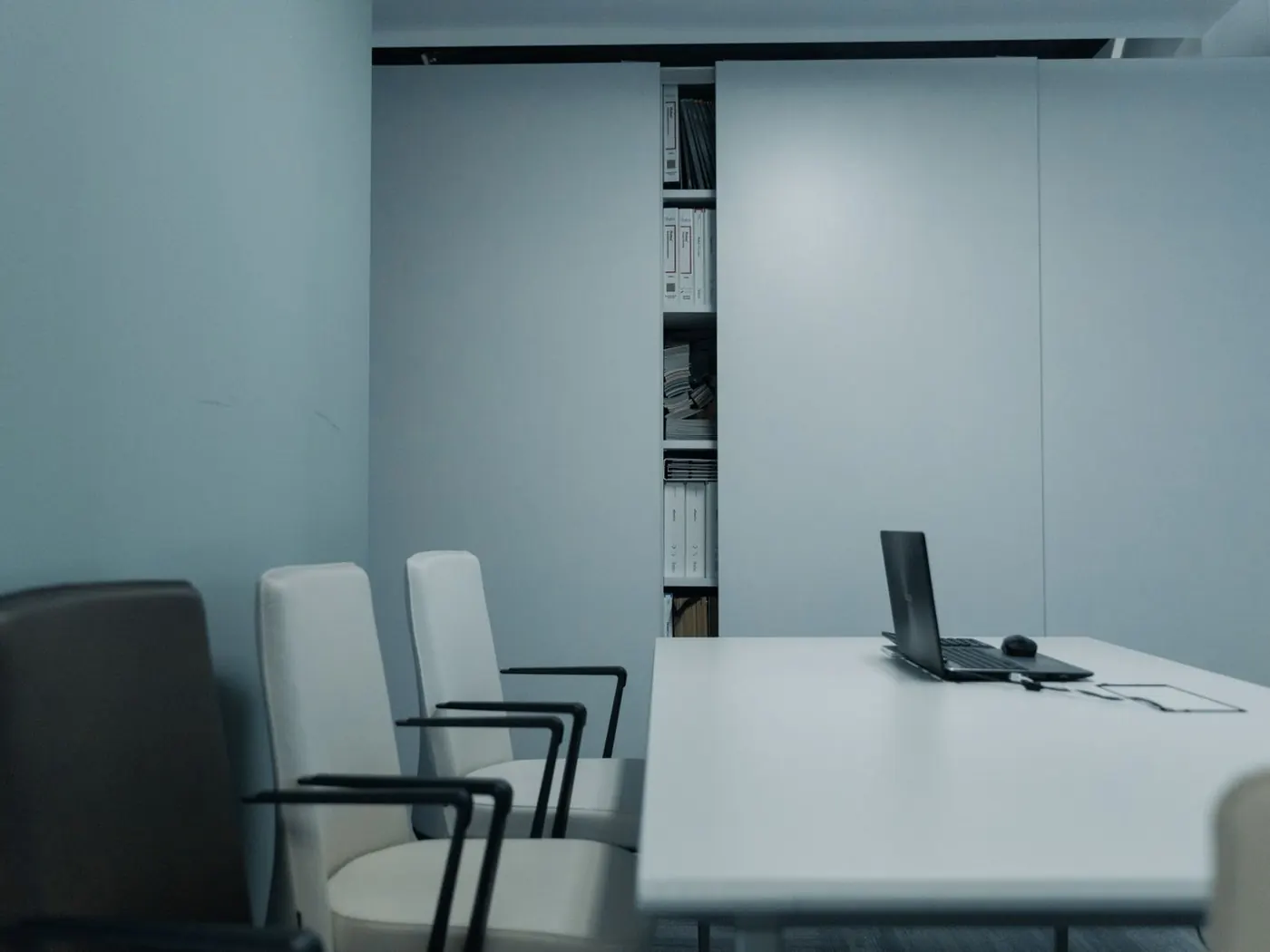 Sala de despacho con una mesa clara, sillas y archivadores al fondo